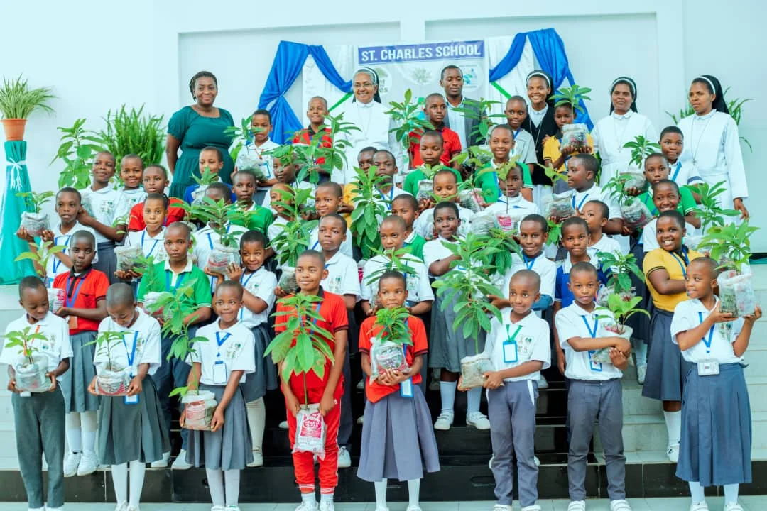 Pupils and staff taking part in a school tree-planting activity.