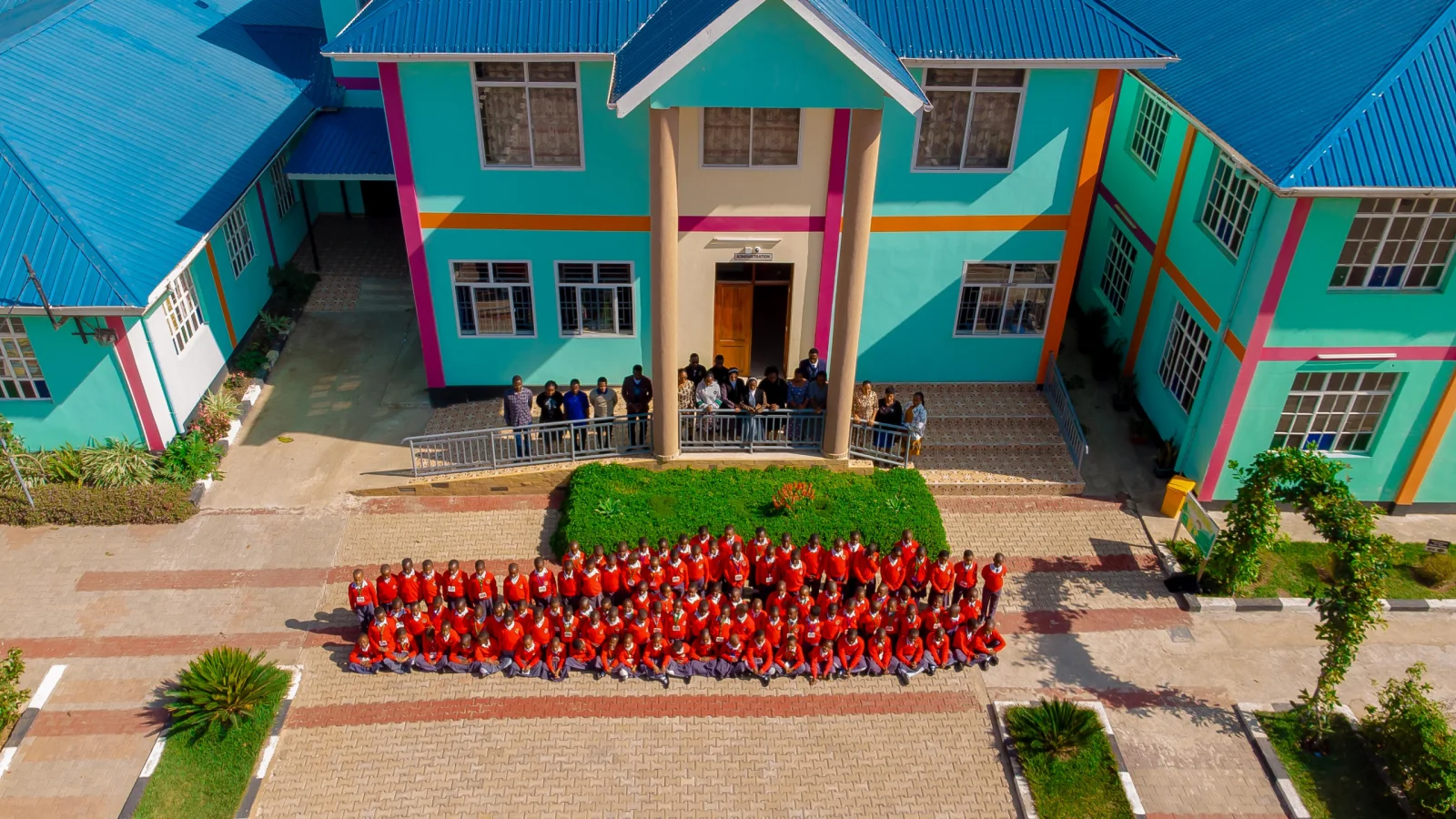 Pupils and staff gathered in front of the administration block.